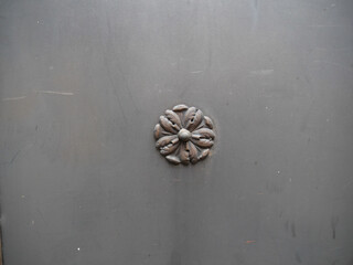 Stilisierte Metall-Blume als Dekor auf einer Stahltüre als Deko