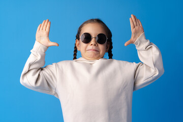 Funny little girl with braids on blue background