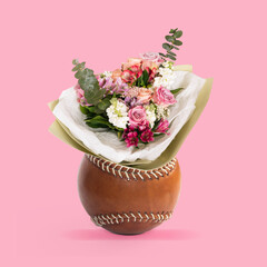 A bouquet of flowers in a vase in the form of a brown leather baseball isolated on a pink background. Trendy collage in magazine style. Contemporary art. Modern design