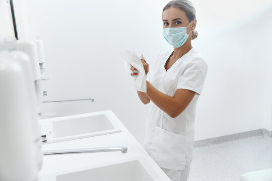  Portrait of female doctor or nurse drying hands with paper tissue at hospital after Washing Hands. Hygiene, health care.