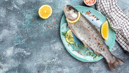 Fresh rainbow trout with salt, pepper, lemon and rosemay. Tasty fishes preparing for lunch. Healthy eating concept. banner, menu, recipe place for text, top view