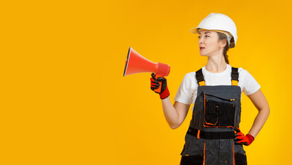 Megaphone in builder hand. Woman repairman with red megaphone. Girl repairman on yellow. Layout for advertising banner. Place for text. Banner for construction company. Woman builder in overalls