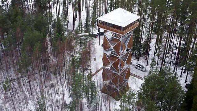 Approaching aerial drone view of a viewing tower in a bog during winter. Recorded in Valgesoo, Estonia.