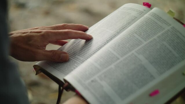 Peaceful Bible Reading and page flipping through leather book pages on beach shore