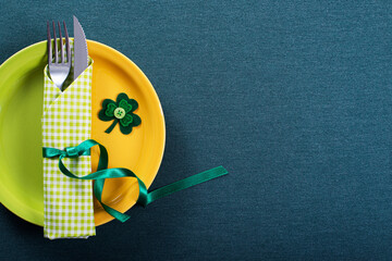 Dish with silverware in green napkin for St Patrick day on table