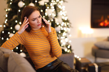 Confused lady talking on cellphone sitting on couch