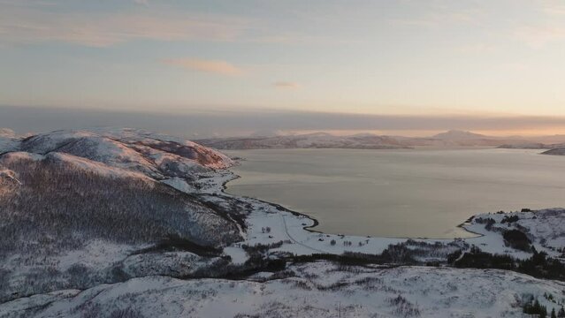Beautiful aerial view snowy mountains and lakes at sunrise on Kvaloya Island