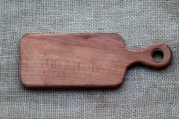 Empty wooden kitchen board on canvas background. Top view