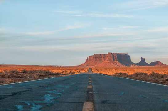 Long and empty road in monument valley with beautiful sunsent light