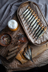 Cold smoked fish on an old wooden board with spices.