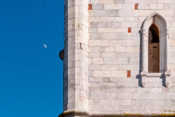 Photo sur Aluminium Tour de Pise A detail of the bell tower of the church of San Lorenzo Martire, Orentano, Pisa, Italy, with the crescent moon in the background
