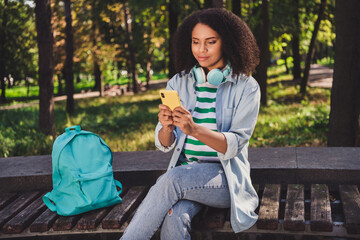 Photo of young attractive african girl use smartphone addicted post comment like modern device outdoors
