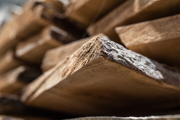 wooden planks from a natural tree stacked on top of each other in a carpentry shop, photographed close up macro 