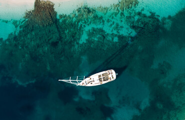 Wellen und Yacht von oben. Türkisfarbener Wasserhintergrund von oben. Sommermeerblick aus der Luft. Draufsicht von der Drohne. Reisebild