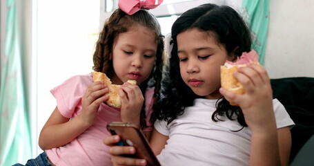 Kids eating sandwiches while looking at smartphone, children snacking while on social media