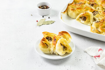 Chicken Alfredo stuffed conchiglioni pasta shells. Space for text.