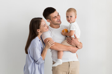 Portrait Of Happy Family Of Three With Adorable Toddler Son Posing Together
