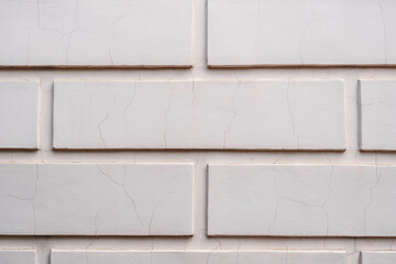Cracked plaster on an old wall with a weathered rough surface. Block shapes. Vintage texture perfect for background and design.