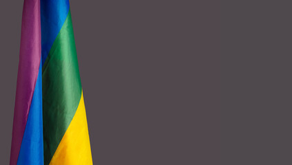 Close-up of the rainbow flag or LGBT flag is on the left side on a gray background