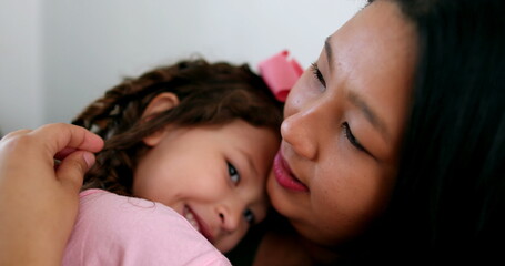 Cute little girl hugging and loving mom. Candid authentic affection and love between mother and child