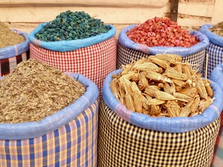 Close up of fabric bags filled with colorful herbs and spices in souk of Marrakech, Morocco.