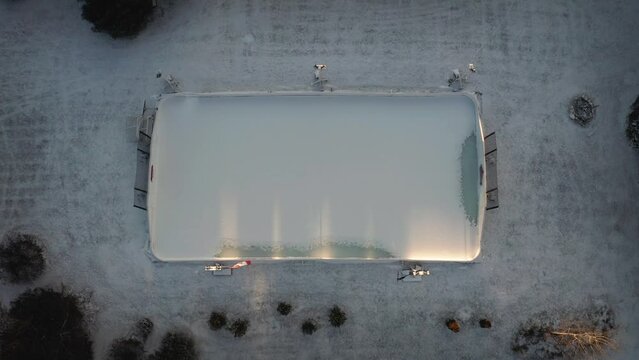 Top down drone video of outdoor hockey rink in Canada in winter