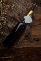 250 ml bottle of red wine with blank label on wooden shavings background. Cabernet sauvignon,...