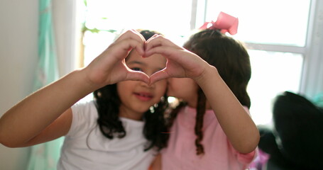 Fototapeta premium Children doing heart symbol with hands together close-up