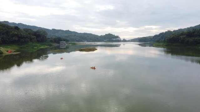 Asian People canoeing on a reservoir with a beautiful view