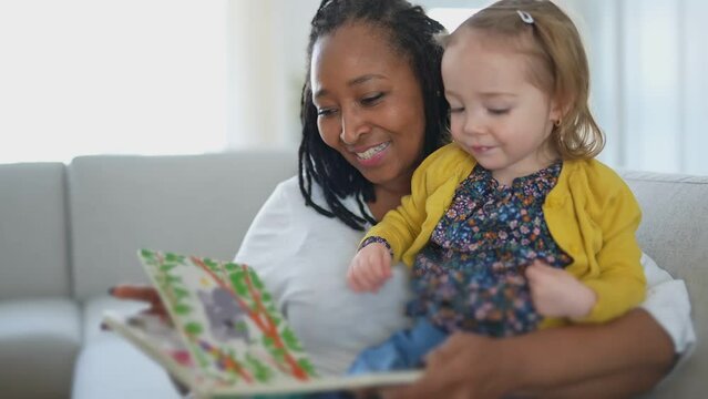 babysitter black woman read book with little child girl