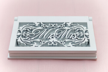 Mr. and Mrs. white initials wedding box on pink tablecloth background. Just married presidium, festive accessories.