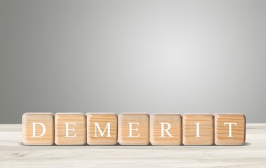 DEMERIT; Wooden blocks with text of concept.
