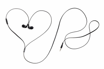 Ear plugs for music lovers in the shape of a heart. Earphones headset on a white background. Vacuum wired black headphones for listening music and sound on portable devices. In-ear headphones.
