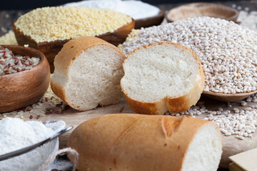 Fototapeta na wymiar wheat baguette on the table with flour and various plant grains