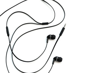 Black wired vacuum earplugs isolated on a white background. Headphones headset. In-ear headphones for listening music and sounds on portable devices.