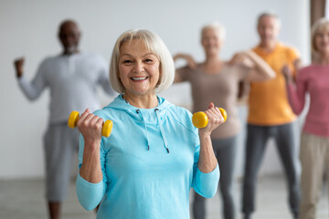 Seniors doing strength building fitness exercises with dumbbells