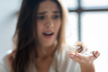 Closeup Of Stressed Young Woman Holding Bunch Of Fallen Hair In Hand - obrazy, fototapety, plakaty