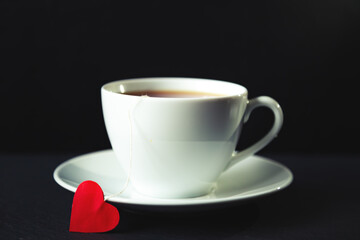 White cup of tea on a black background.