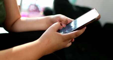 Asian woman typing on cellphone device