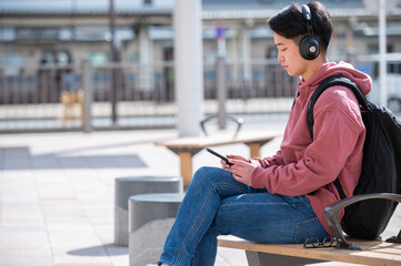 音楽を聴きながらバスを待つ男性