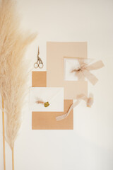 Vertical image peach mock up composition of paper gift envelopes with ribbons, scissors, cutting out handmade. Flat lay.