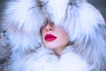 Russian girl in a fur hat, beautiful red lips and blue eyes, premium