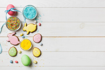 holiday preparation Multi colors Easter eggs with cookies on colored background . Pastel color Easter eggs. holiday concept with copy space