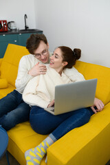 a young beautiful couple shopping online. The girl buys herself a gift. The woman is happy with the purchase