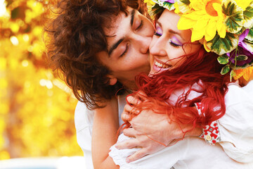 Fototapeta premium Wedding in traditional costumes of Slavic peoples. People in Ukrainian, Polish, Slovak, Hungarian national clothes. A girl with a wreath on her head. Happy couple in nature