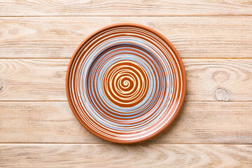 Fototapeta na wymiar Top view of empty colorful plate on wooden background. Empty space for your design