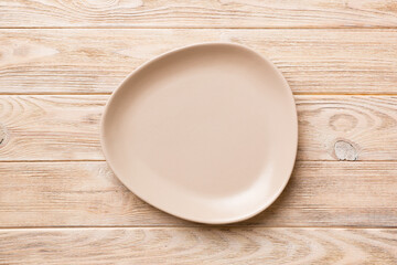 Top view of empty pink plate on wooden background. Empty space for your design
