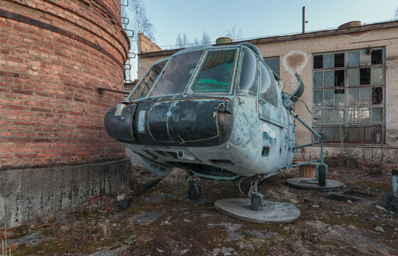 Abandoned blue military helicopter near the destroyed building