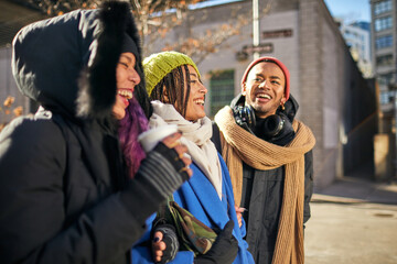 Obraz premium USA, New York City, Smiling friends on street on cold day