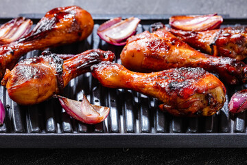 Grilled chicken drumsticks and red onion